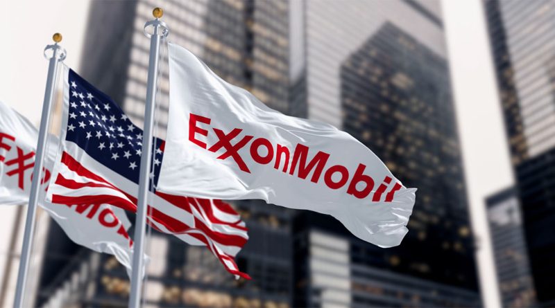 Image of the Exxon Mobil logo on a flag next to the American flag blowing in the wind in a city centre to supply environmental news article
