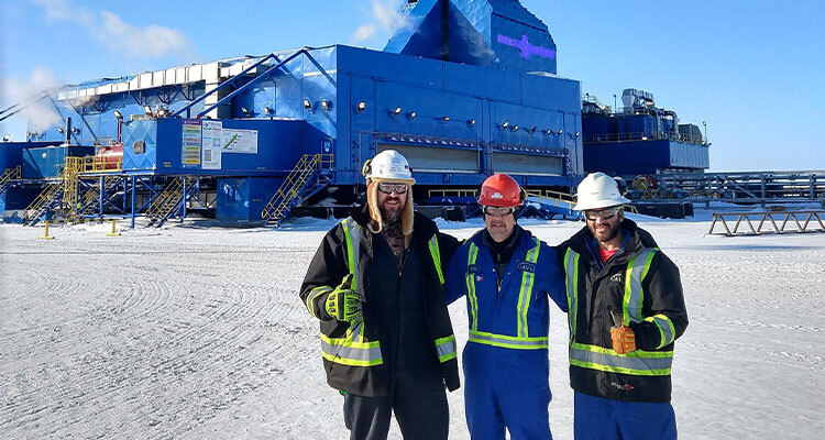 Workers standing in front of Oil Rig in the snow