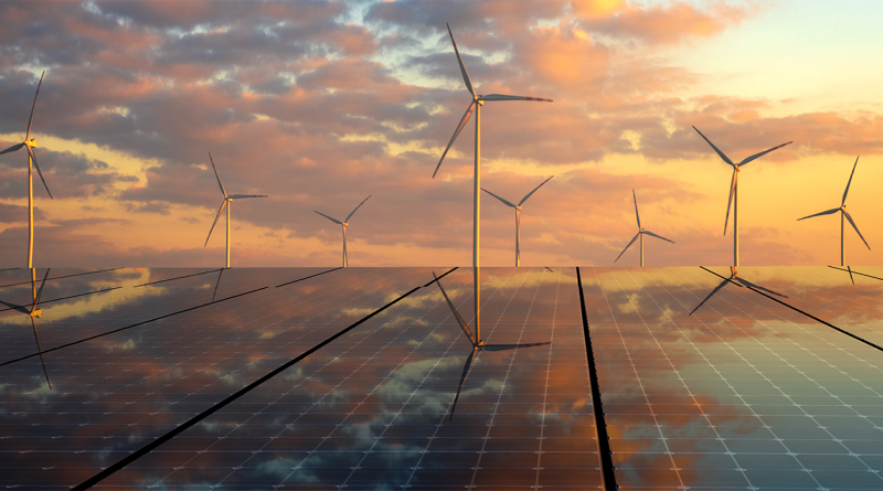 Panoramic image of multiple wind turbines stood on top of solar panels in front of a sunset to support clean energy article