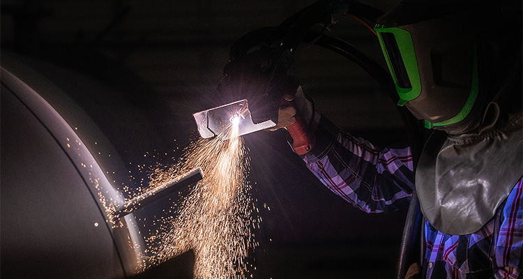 Construction worker in protective clothes working on equipment to support Apache Industrial article