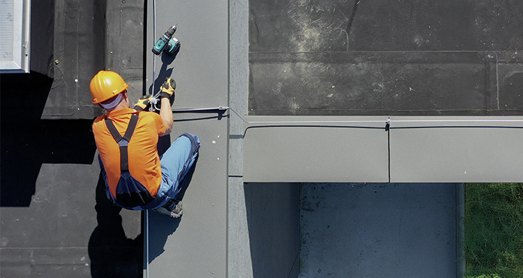 a worker conducting a lightning protection system test or inspection on a building