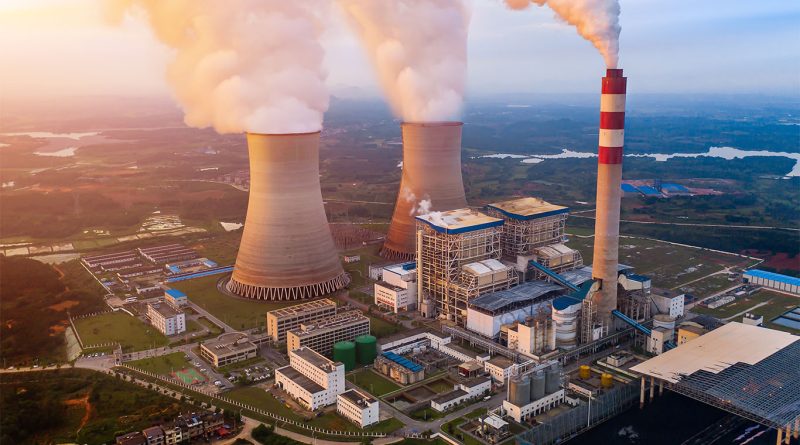 Oil refinery with smokestacks emitting fumes under a hazy sky, symbolizing fossil fuel expansion and climate challenges.