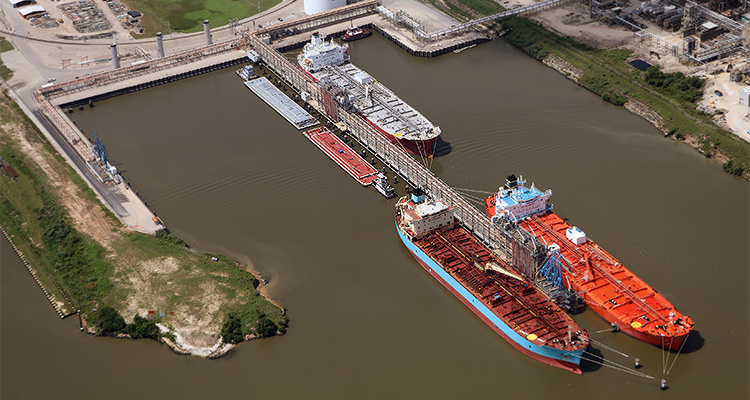 several ships, including two large tankers, docked at a port facility