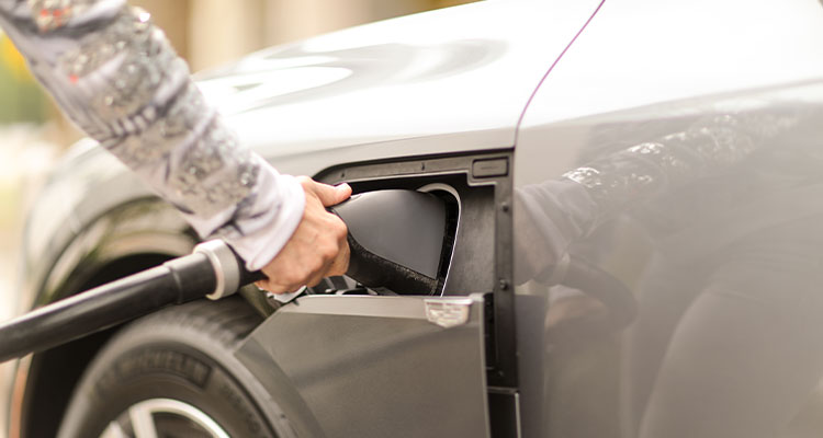 a person plugging a charging cable into an electric vehicle