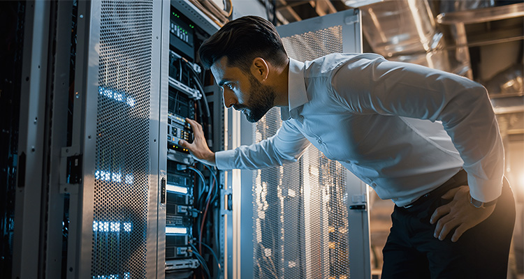 OT cybersecurity issues facing the UK energy industry a man in a white shirt looking into a server cabinet